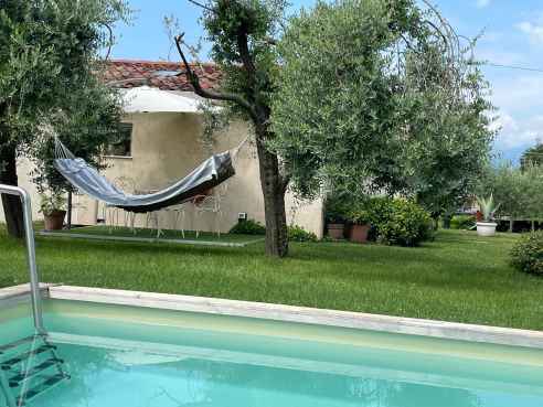 Immagine con piscina nell'angolo e casa alloggio sullo sfondo