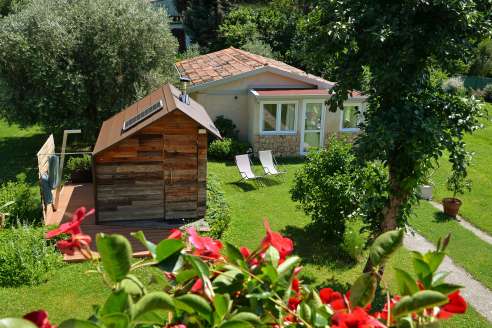 Veduta dall\'alto del giardino con casa, sauna e l'area relax