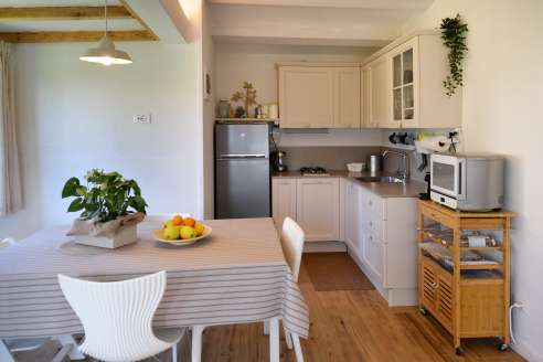 Foto della cucina con frigo, tavolo, e mobili